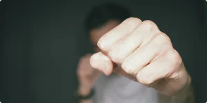 A close-up of a man's clenched fist, showcasing the details of the skin and knuckles.