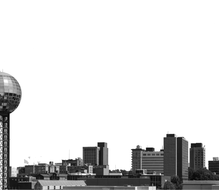 Black and white photo showcasing a city skyline with tall buildings against a cloudy sky.