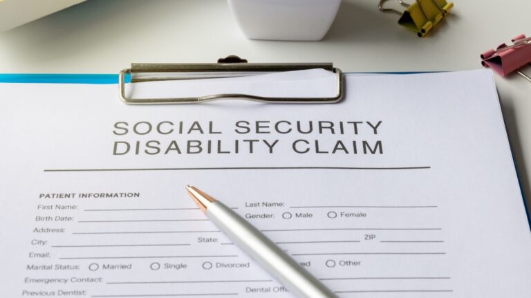 Social Security Disability Claim form and pen on desk