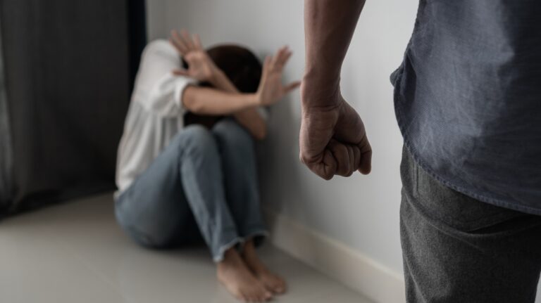 Woman covering her face in fear of domestic violence