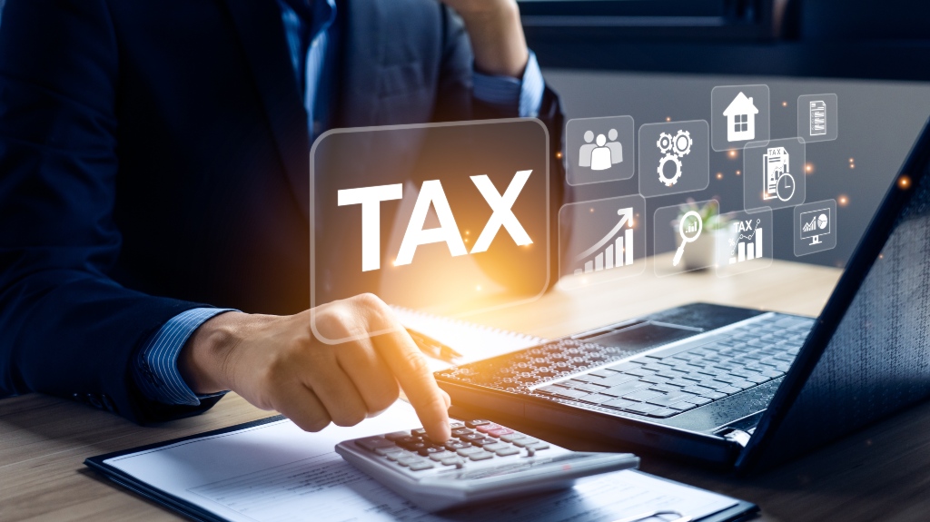 man doing calculations on calculator and glowing TAX sign