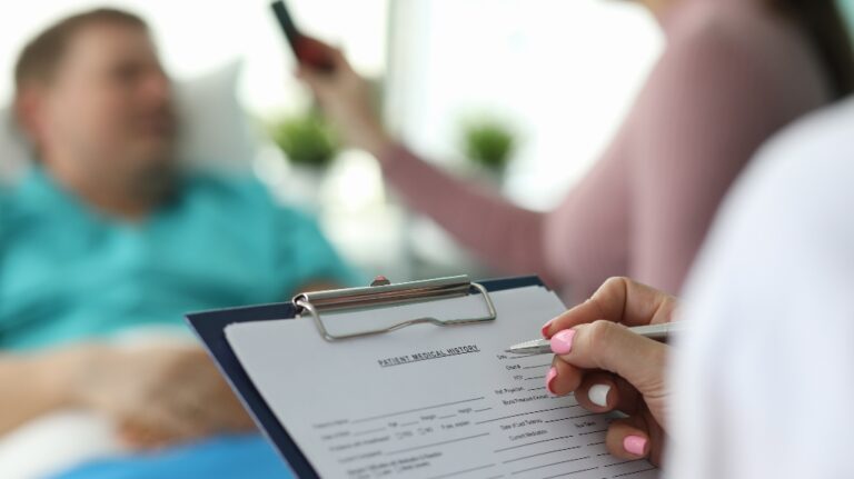 Female doctor fills in patient medical record