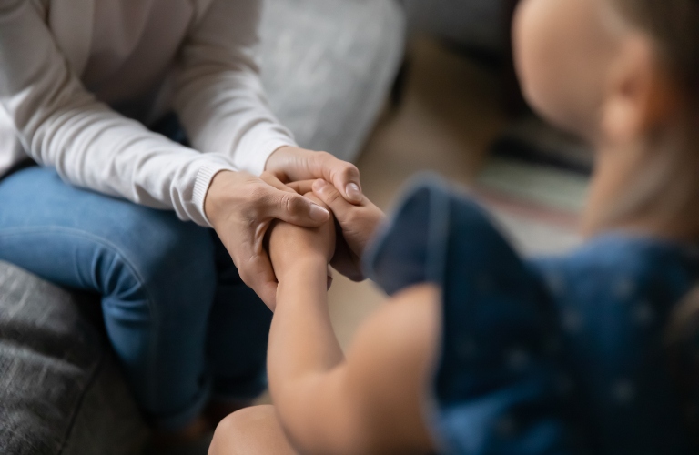 mother is holding little girl's hands