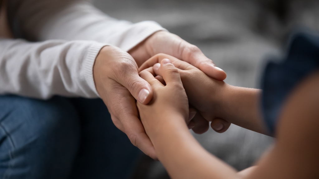 parent holding hands of little kid girl