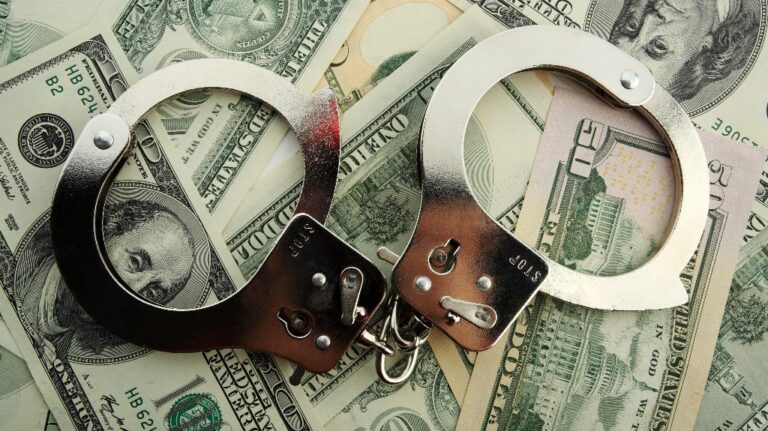 Silver handcuff and dollar