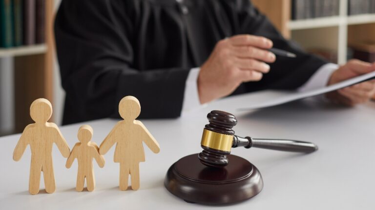 Wooden figurines of family with child and judge's gavel