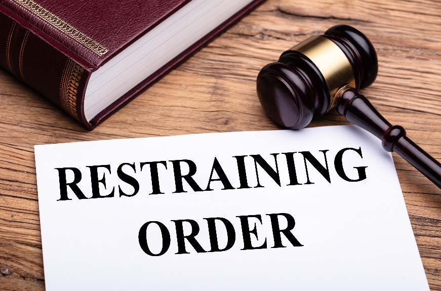 Document with restraining order title near judge's gavel